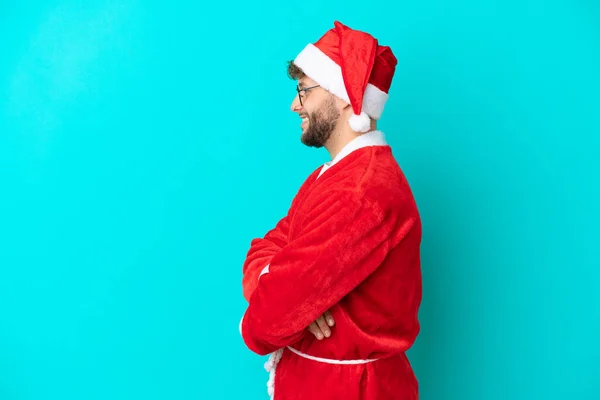 Jongeman Vermomd Als Kerstman Geïsoleerd Blauwe Achtergrond Laterale Positie — Stockfoto