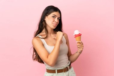 Kornet dondurmalı beyaz bir kadın pembe arka planda soyutlanmış gururlu ve kendini beğenmiş.