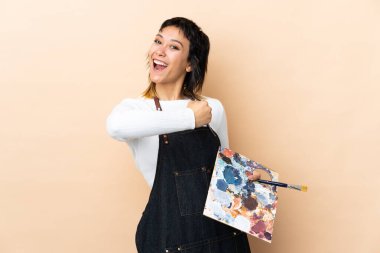 Arkaplanda palet tutan genç bir sanatçı zaferi kutluyor.