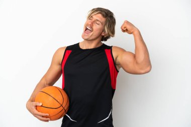 Beyaz arka planda izole edilmiş basketbol topu tutan genç sarışın bir adam zaferi kutluyor.