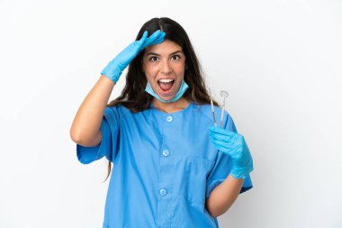 Dişçi kadın beyaz arka plan üzerinde araçları tutmak sürpriz ifade ile