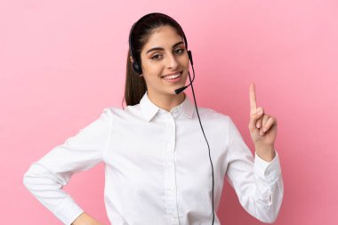 Genç pazarlamacı, izole edilmiş arka planda en iyinin işareti olarak parmağını kaldırıyor ve gösteriyor.