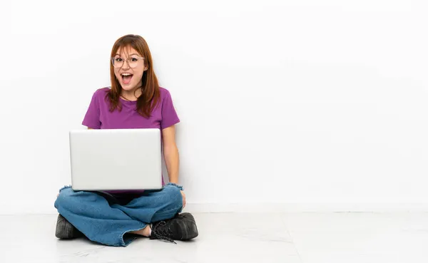 Rothaariges Mädchen Mit Laptop Sitzt Mit Überraschendem Gesichtsausdruck Auf Dem — Stockfoto