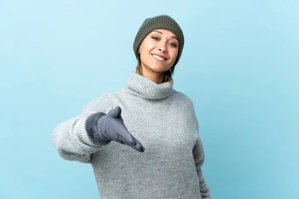 Junge Uruguayische Mädchen Mit Wintermütze Isoliert Auf Blauem Hintergrund Händeschütteln — Stockfoto