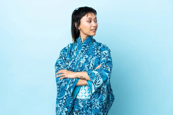 Kimono Giyen Genç Bir Kadın Mavi Arka Planda Yana Bakıyor — Stok fotoğraf
