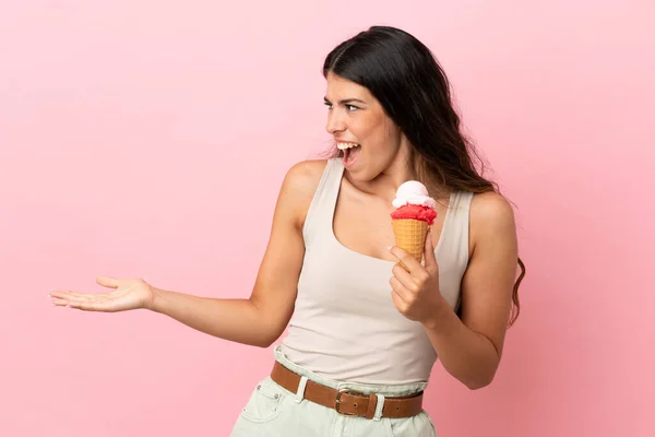 분홍색 배경에 아이스크림을 코카서스 여성이 표정으로 바라보고 있었다 — 스톡 사진