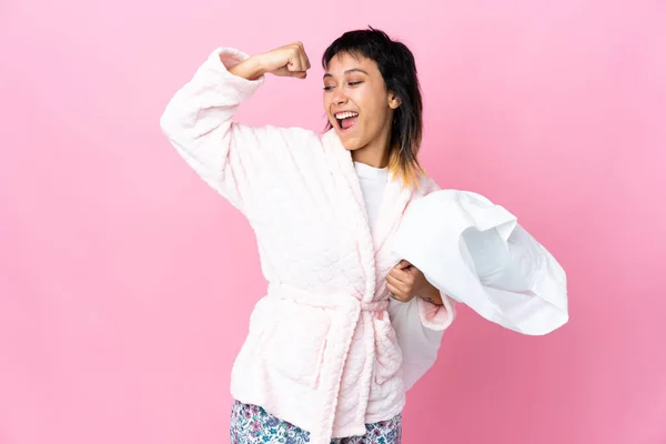 若いですウルグアイ女性でパジャマ上の隔離されたピンクの背景祝いますA勝利 — ストック写真