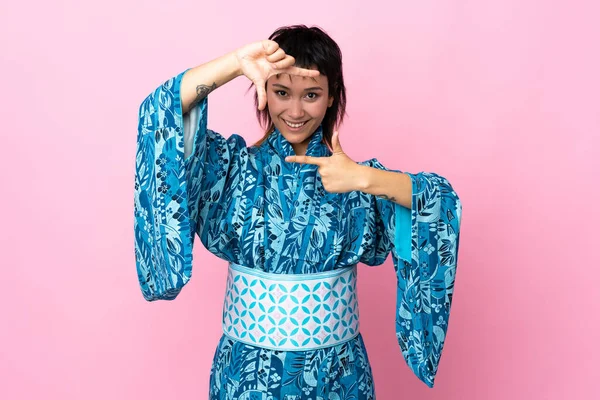 Mujer Joven Que Usa Kimono Sobre Fondo Azul Aislado Enfocando —  Fotos de Stock