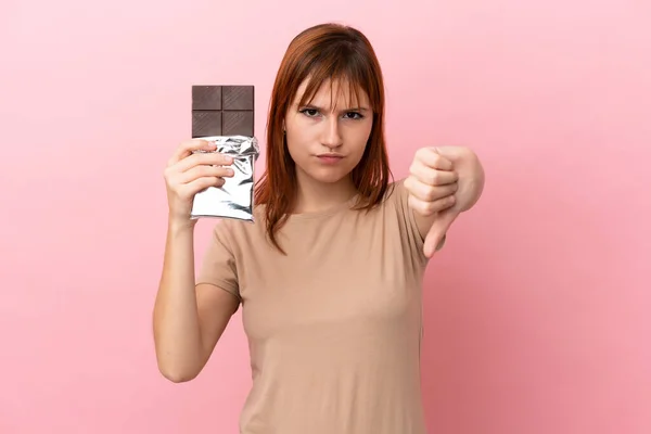 Zrzka Dívka Izolované Růžovém Pozadí Čokoládovou Tabletu Dělat Špatný Signál — Stock fotografie