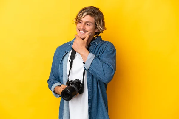 Sarı Arka Planda Izole Edilmiş Genç Fotoğrafçı Yana Bakıyor Gülümsüyor — Stok fotoğraf