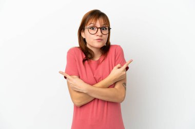 Kızıl saçlı kız beyaz arka planda izole edilmiş. Yan taraftakilerin şüpheleri olduğunu gösteriyor.