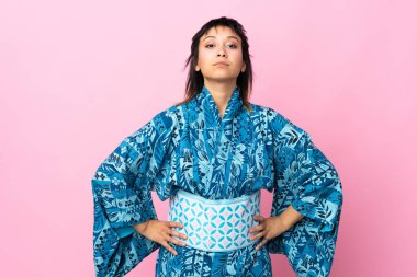 Kimono giyen genç bir kadın izole edilmiş mavi arka planda kızgın.