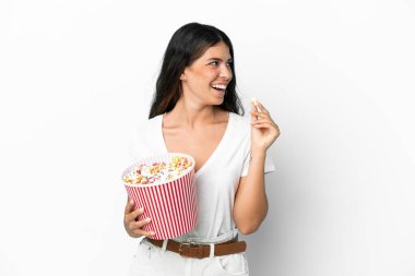 Beyaz arka planda izole edilmiş beyaz bir kadın elinde koca bir kova patlamış mısır tutuyor.