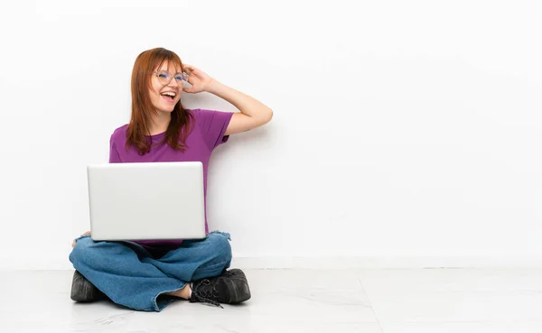 Rothaarige Mädchen Mit Einem Laptop Auf Dem Boden Sitzen Und — Stockfoto