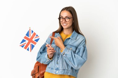 Birleşik Krallık bayrağını izole edilmiş beyaz arka planda tutan genç İspanyol kadın parmak kenarı işaret ediyor.