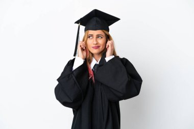 Tecrit edilmiş beyaz arka planda genç üniversite mezunu hayal kırıklığına uğramış ve kulaklarını kapatmış