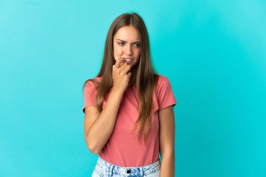 Soyutlanmış mavi arka plan gergin ve korkmuş genç bir kadın.