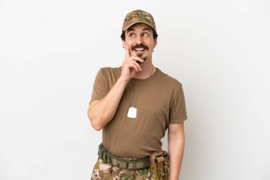 Beyaz arka planda izole edilmiş bir asker yukarı bakarken bir fikir düşünüyor.