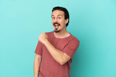 Mavi arka planda izole edilmiş beyaz bir adam zaferi kutluyor.