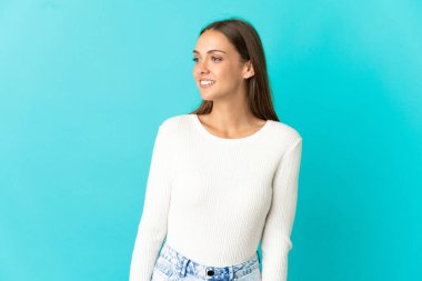 İzole mavi arka plan görünümlü yan üzerinde genç kadın