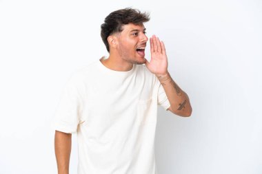 Beyaz arka planda izole edilmiş, ağzı açık, bağıran beyaz, yakışıklı genç bir adam.