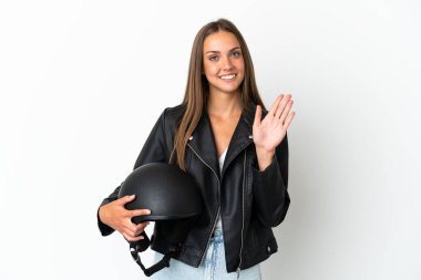 İzole edilmiş beyaz arka planda motosiklet kasklı bir kadın mutlu bir ifadeyle selamlıyor.