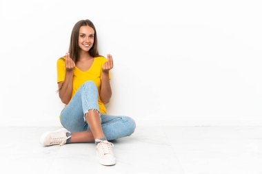 Genç kız yerde oturup para hareketi yapıyor.