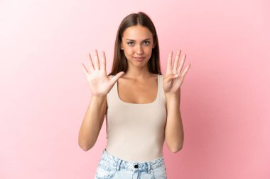 Soyutlanmış pembe arka planda dokuz parmaklı genç kadın.