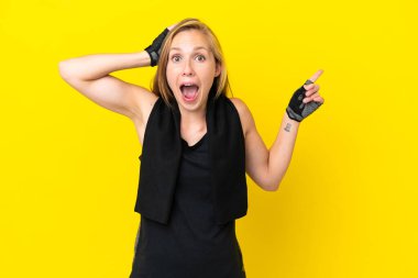 Beyaz arka planda izole edilmiş genç bir İngiliz kadın. Şaşırmış ve işaret ediyor.