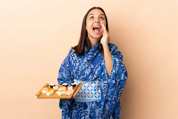Frau Trägt Kimono Und Hält Sushi Über Isoliertem Hintergrund Schreit — Stockfoto
