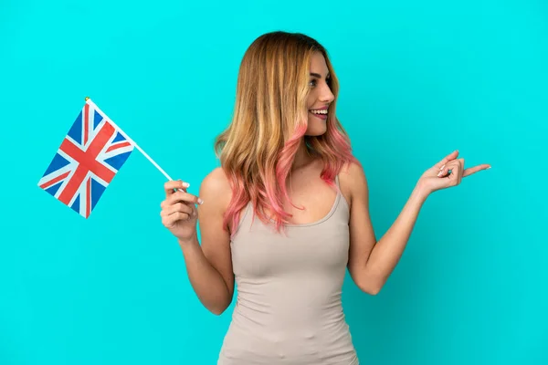Ung Kvinna Som Håller Brittisk Flagga Över Isolerad Blå Bakgrund — Stockfoto