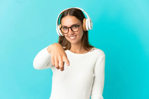 Mujer Joven Sobre Fondo Azul Aislado Escuchando Música — Foto de Stock