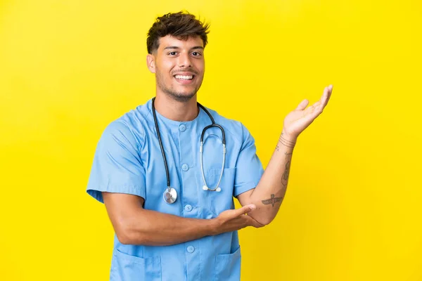 Jovem Cirurgião Homem Médico Isolado Fundo Amarelo Estendendo Mãos Para — Fotografia de Stock
