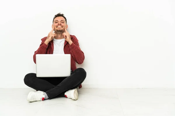 Jovem Caucasiano Bonito Sentar Chão Com Laptop Sorrindo Com Uma — Fotografia de Stock