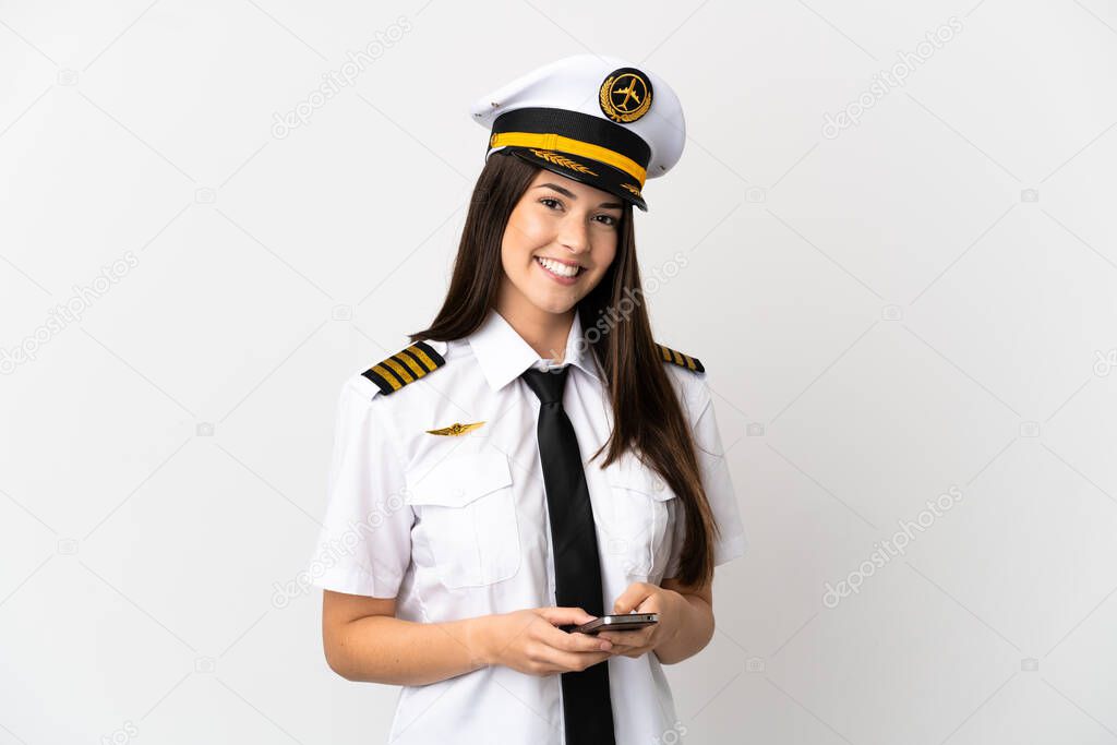 Brazilian girl Airplane pilot over isolated white background sending a message with the mobile