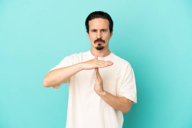 Kafkasyalı genç adam mavi arka planda izole edilmiş.