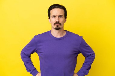 Genç beyaz adam sarı arka planda izole edilmiş kızgın.