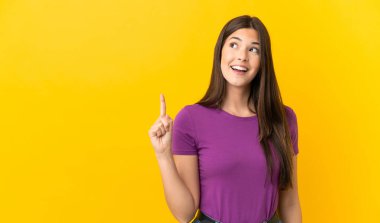 İzole edilmiş sarı arka plan üzerinde Brezilyalı genç bir kız parmağını kaldırarak çözümü bulmaya çalışıyor.