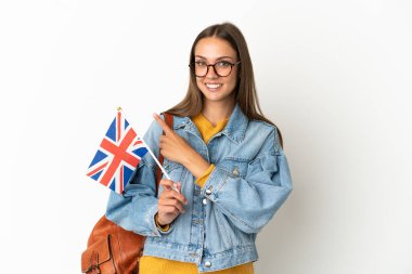 Birleşik Krallık bayrağını tek başına beyaz arka planda tutan genç İspanyol kadın bir ürünü sunmak için kenarı işaret ediyor.