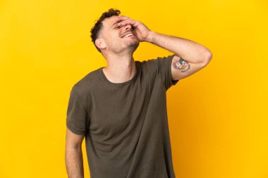 Beyaz tenli yakışıklı adam sarı arka planda izole edilmiş, gülümsüyor.