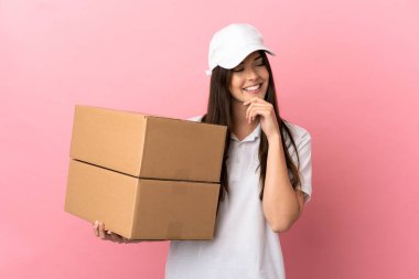 Yalıtılmış pembe duvarın üzerinden teslimatçı kız yana bakıyor ve gülümsüyor