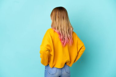 Arka planda soyutlanmış mavi arka planda genç bir kadın var.