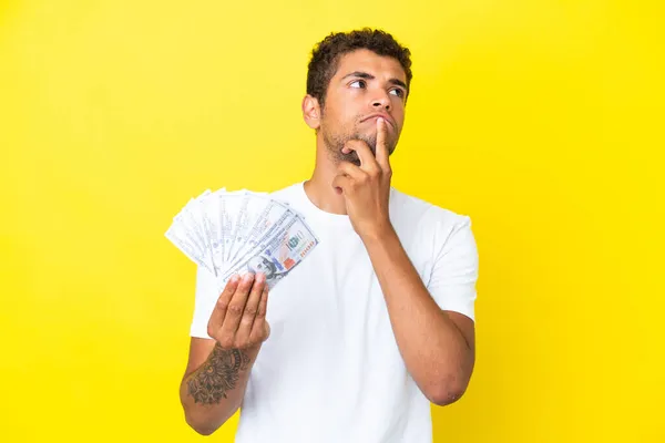 Joven Brasileño Tomando Montón Dinero Aislado Sobre Fondo Amarillo Teniendo — Foto de Stock