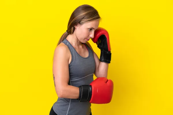 若いです英語の女性はボクシング手袋で黄色の背景に隔離 — ストック写真