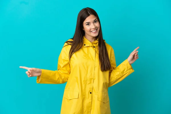 Adolescente Brésilienne Portant Manteau Imperméable Sur Fond Bleu Isolé Pointant — Photo