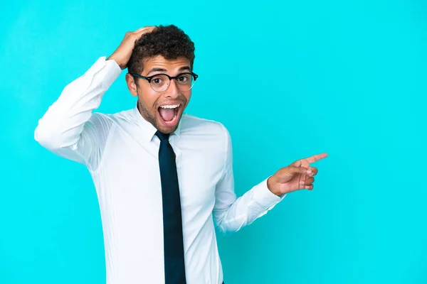 Young Business Brazilian Man Isolated Blue Background Surprised Pointing Finger — Stock Photo, Image