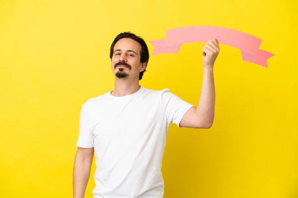 Joven Hombre Caucásico Aislado Sobre Fondo Amarillo Sosteniendo Cartel Vacío — Foto de Stock