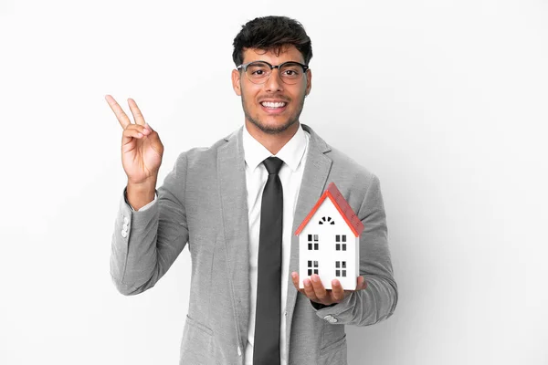 Uomo Affari Possesso Una Casa Isolata Sfondo Blu Sorridente Mostrando — Foto Stock