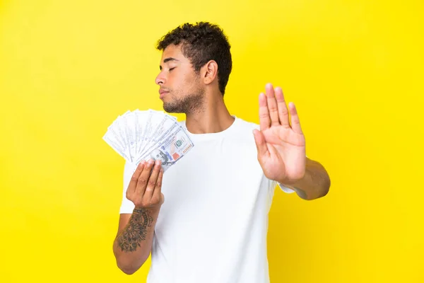 Jonge Braziliaanse Man Neemt Veel Geld Geïsoleerd Gele Achtergrond Maken — Stockfoto