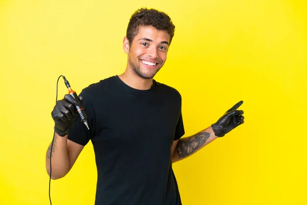 纹身艺术家巴西男子孤立在黄色背景下 手指指向侧面 — 图库照片
